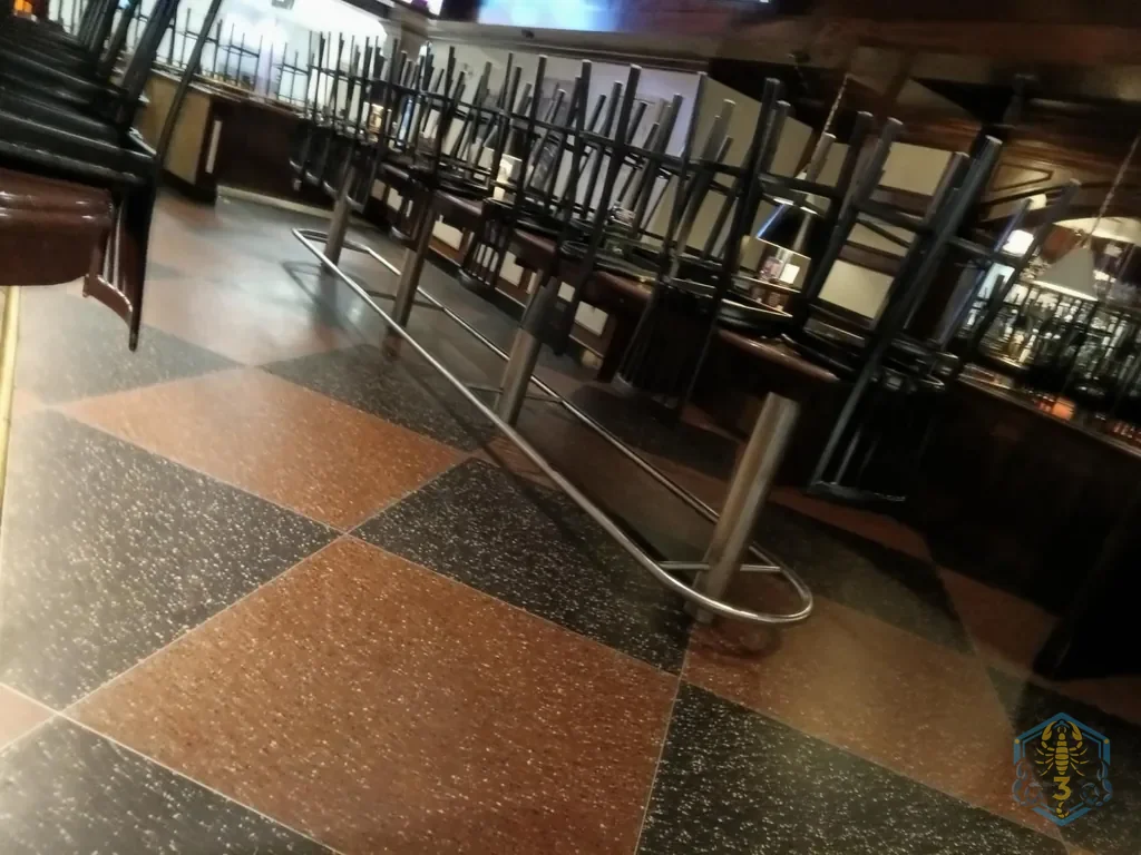 A bar with the stools up on the counter before the floor is done; terrazzo tile looks dull.