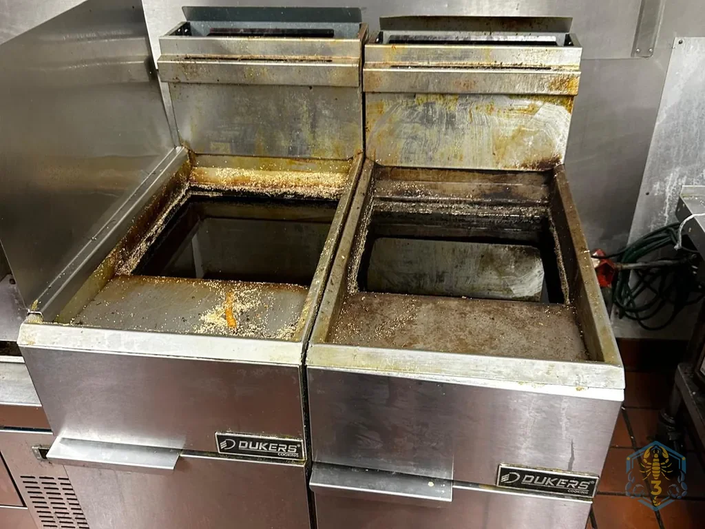 Two fryers before cleaning, tops covered in grease and fried crumbs.