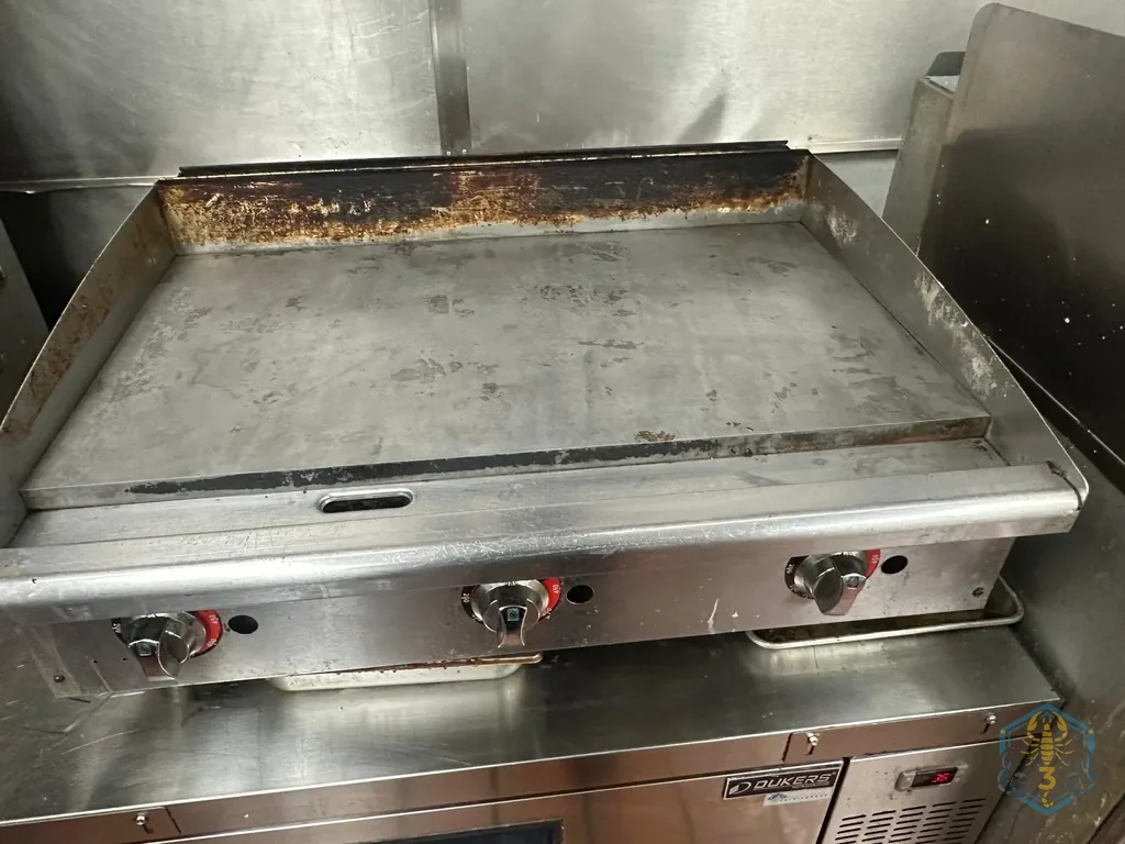 A flat-top griddle scraped clean to bare steel.