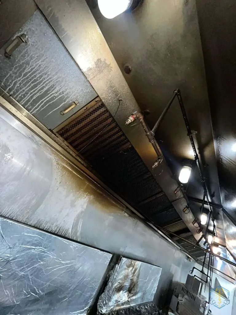 Hood interior before cleaning, with grease visible along the filter housing and the hood seams.