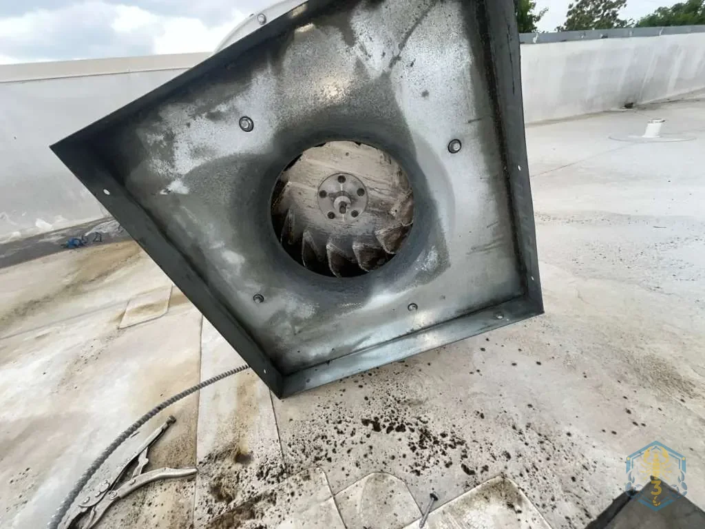 The same rooftop exhaust fan after cleaning: the wheel and housing are washed down to bare metal.